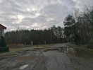 Foto: defekte Zufahrt, Schlaglöcher, riesige Pfützen  