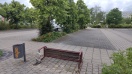Foto: Umgerissene Sitzbank auf Platz neben REWE-Parkplatz 